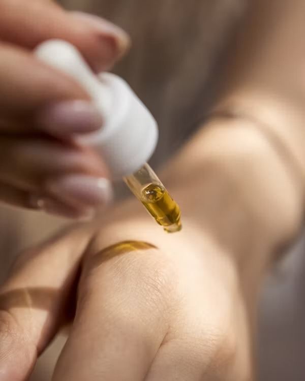 A golden oil drop from a dropper